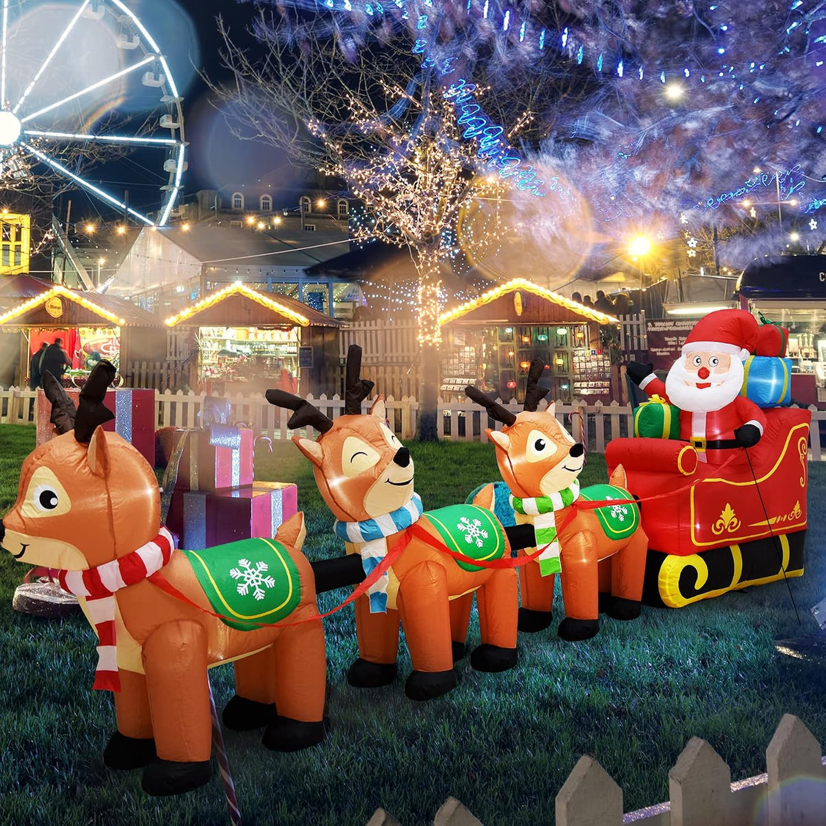 Santa in a red sleigh with a line of reindeer inflatables in a lit Christmas yard