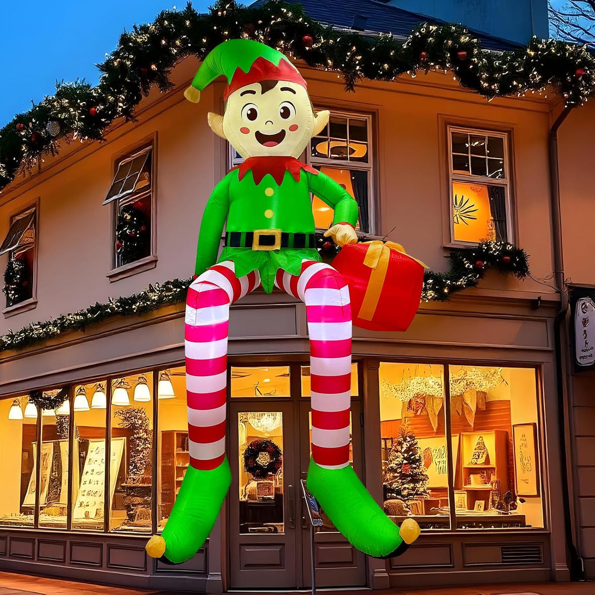 Elf inflatable with striped legs sitting on a shop awning holding a gift