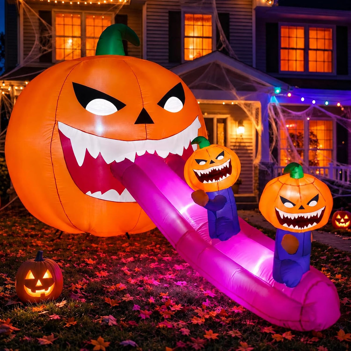 Giant jack-o'-lantern monster inflatable with a long pink tongue and two small pumpkin figures sliding down it